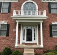 Red brick colonial house with white columns and front entrance portico